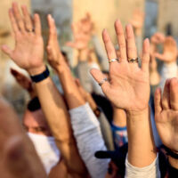 Personas levantando las manos en una manifestación.