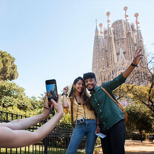 Mujer tomándole fotos a dos personas en la Sagrada Familia