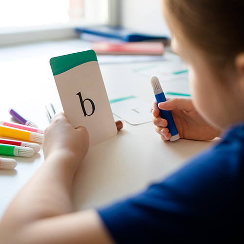 Niña con una carta de "b"