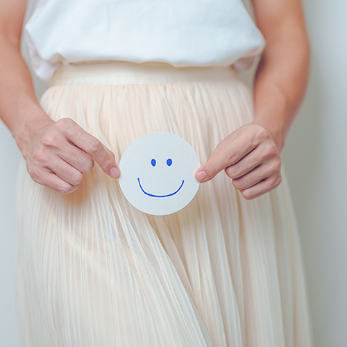 Mujer con una carita feliz en las manos