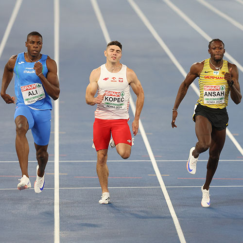 Tres atletas de diferentes etnias corren una carrera. 