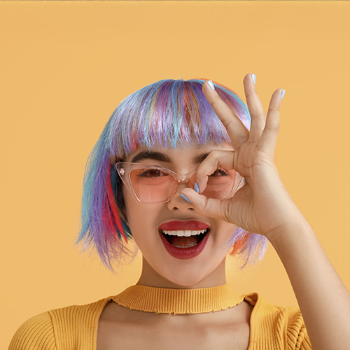 Mujer con peluca de colores con fondo amarillo