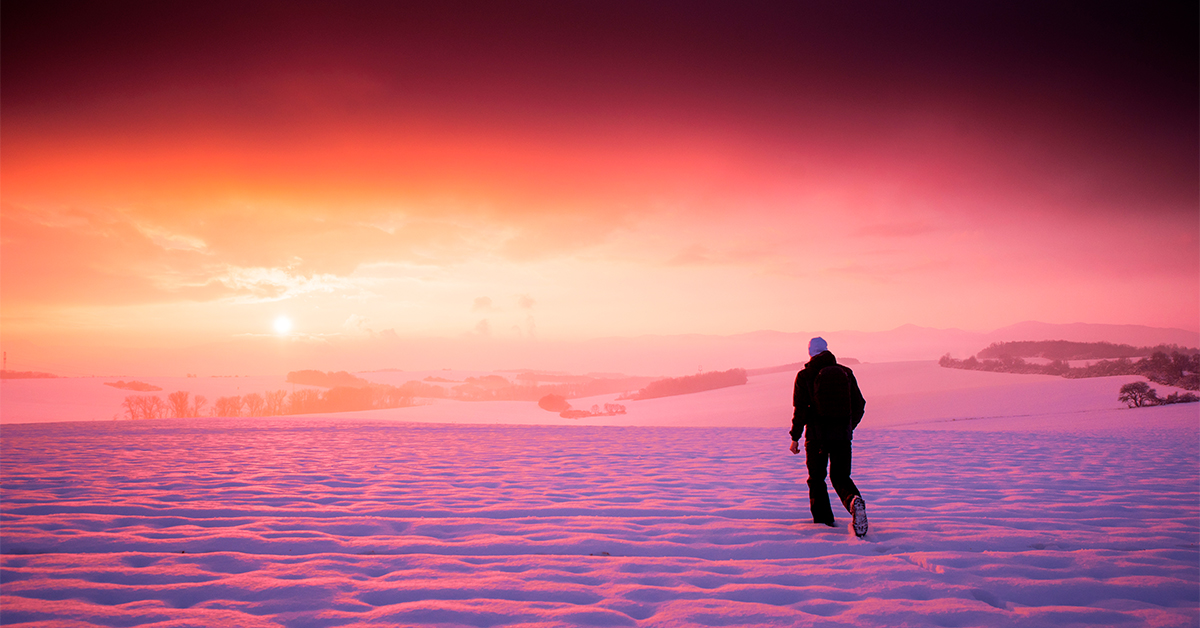 Persona solitaria frente a un paisaje cubierto de nieve